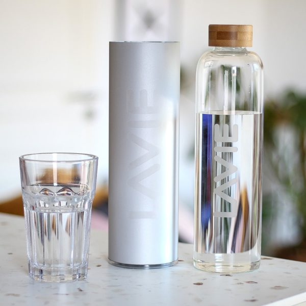 Glass of water, purifier, glass bottle on a table