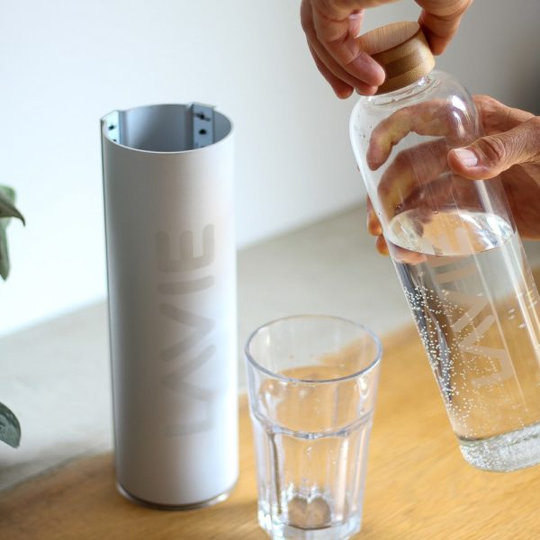 Man pouring water from glass bottle into cup