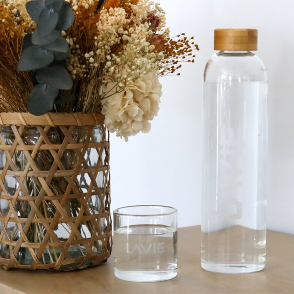 LaVie glass of water next to bottle and flower bouquet